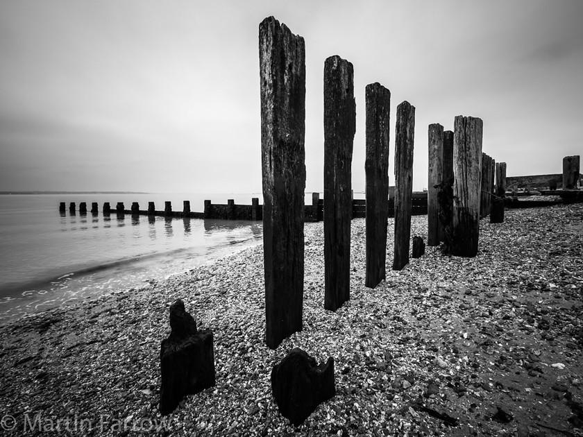 Hill-Head-Piles 
 Row of wooden piles on beach 
 Keywords: Hill Head, beach, coast, sea, shore, water,piles,row,mono,recession,calm