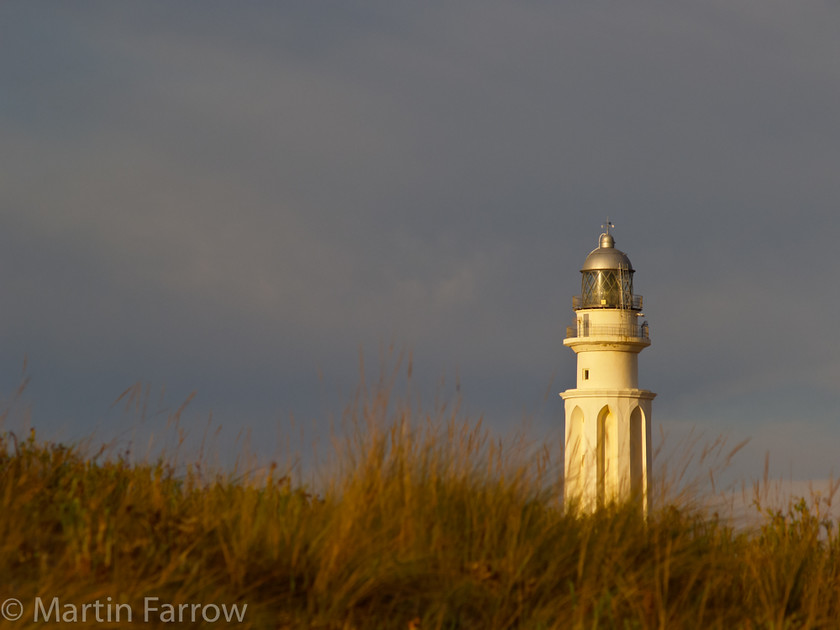 Lighthouse 
 Lighthouse at Cape Trafalgar, Spain in warm evening light 
 Keywords: beach, lighthouse,sun,grass,evening,warm,sea,shore,ocean