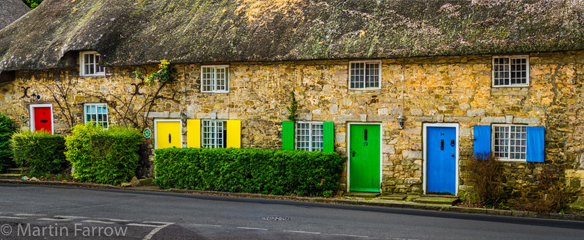 Colour-Coordination 
 Row of thatched cottages with colour coordinated doors and shutters 
 Keywords: West Lulworth, coast to coast, colour, cottages, counteyside, doors, green, nlue, outdoor, red, summer, thatched, yellow