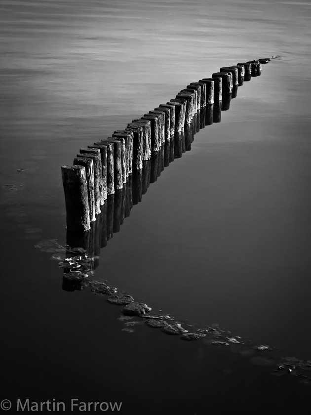 Piles 
 Row of piles in calm water 
 Keywords: piles,water,river,mono,calm,reflections,diagonal