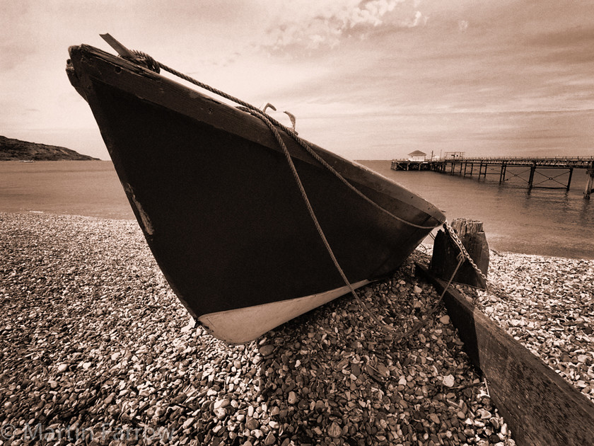 Totland-Pier 
 Boat on shore by Totland pier 
 Keywords: Beaches, IoW, Totland Bay, sea, water, waves,boat,pier,pebbles,coast,shore,beach