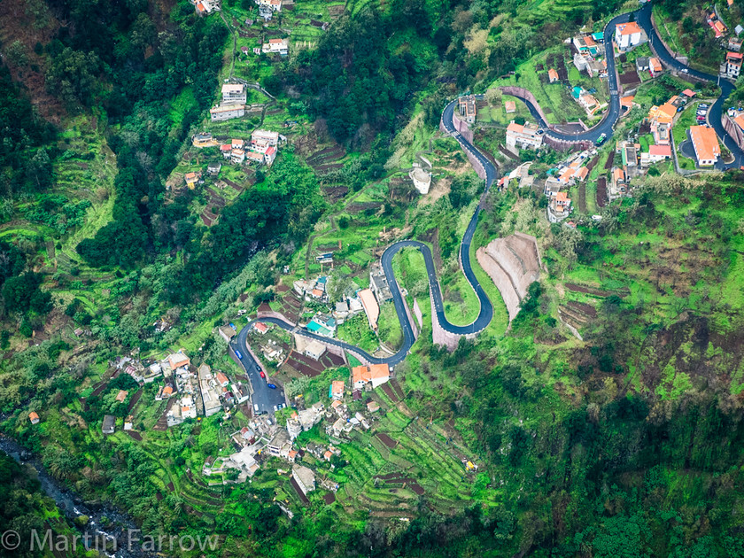 Long-Way-Down 
 View into deep valley with vllage and road snaking to the bottom 
 Keywords: January, Long, Madeira, aerial photo, deep, down, green, high, road, snaking, valley, view, village, way, winter