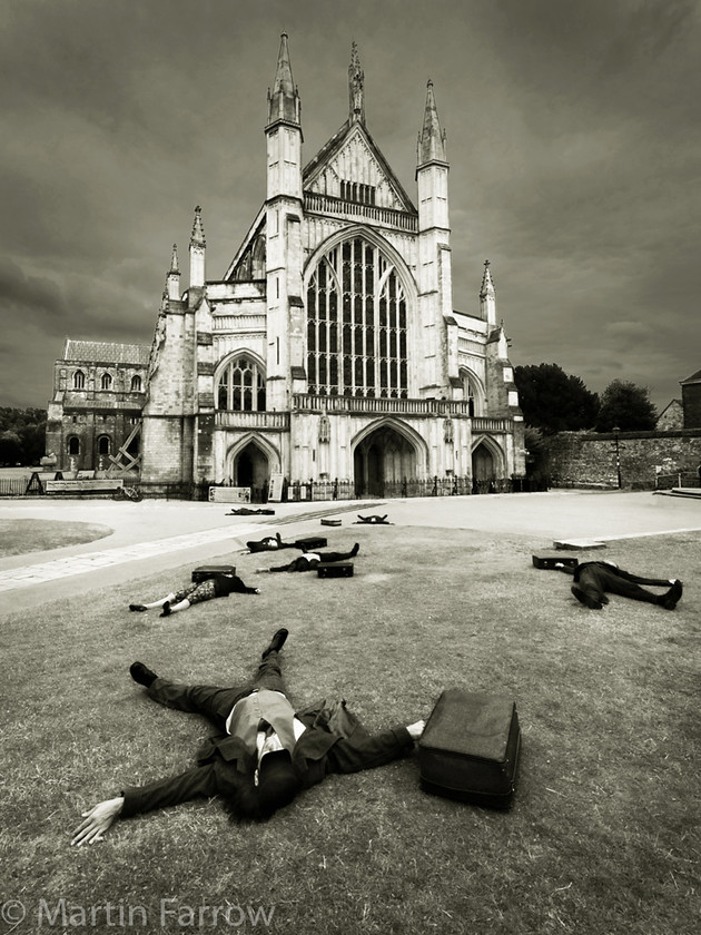 Cathedral-Mystery 
 Bodies in front of Winchester Cathedral 
 Keywords: Hat Fair, Winchester, entertainer, people, performers, street theatre,cathedral,lying,dead,scatter